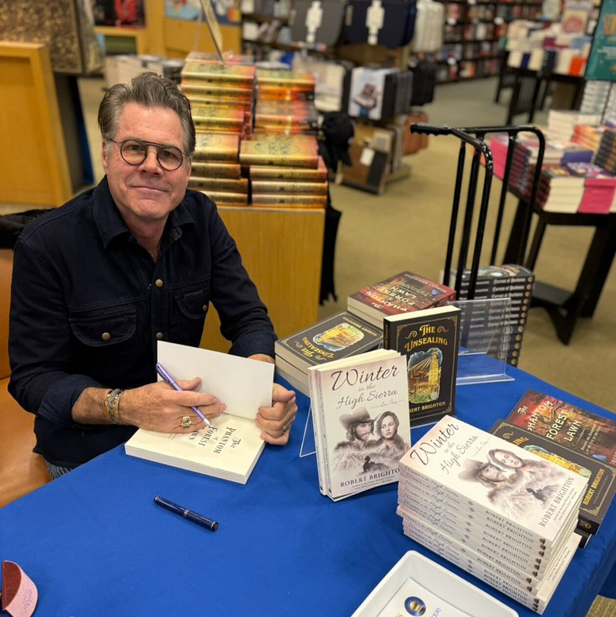 Robert Brighton signing a copy of his book at a bookstore